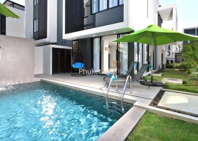 Outdoor pool area with lounge chairs and modern building