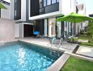 Outdoor pool area with lounge chairs and modern building