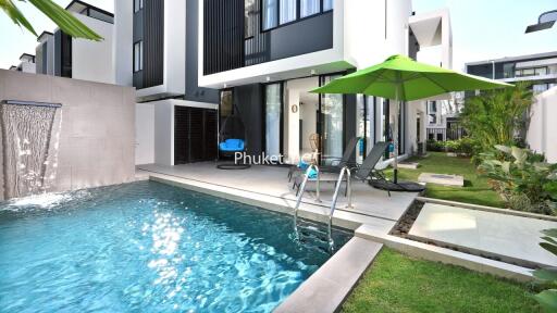 Outdoor pool area with lounge chairs and modern building