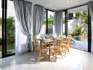 Modern dining area with large windows and garden view