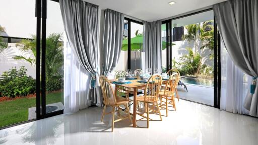 Modern dining area with large windows and garden view