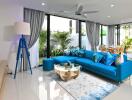 Modern living room with blue sofa and large windows