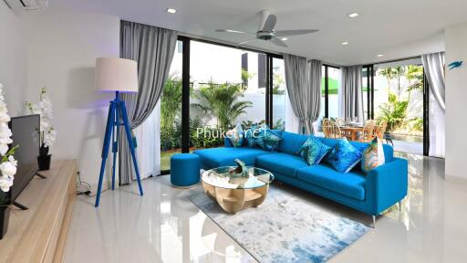 Modern living room with blue sofa and large windows