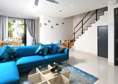 Modern living room with blue sofa and dining area