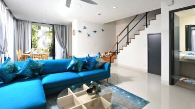 Modern living room with blue sofa and dining area