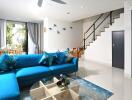 Modern living room with blue sofa and dining area