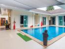 Modern indoor swimming pool area with lounge chairs and decoration