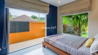 Bedroom with large windows and garden view