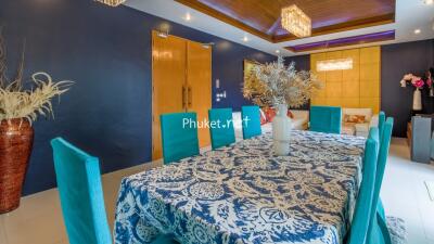 Bright dining room with blue chairs and a patterned tablecloth