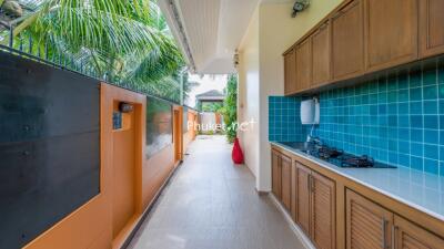 Outdoor kitchen with gas stove and blue tile backsplash