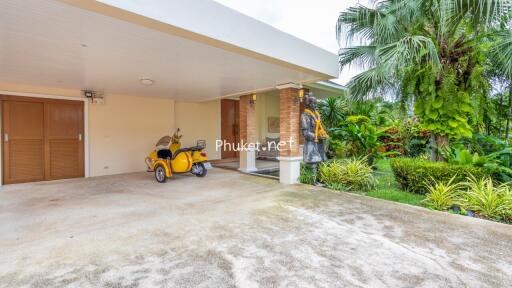 Covered parking area with garden view and motorbike