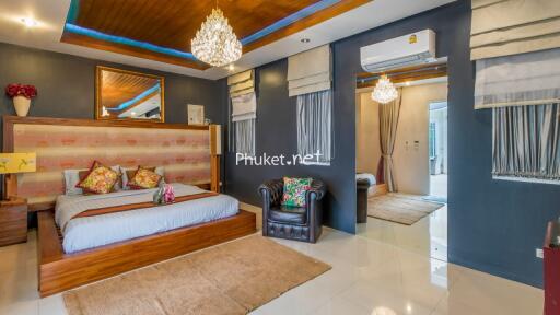 Luxurious bedroom with modern decor featuring a large bed, elegant chandelier, and comfortable seating