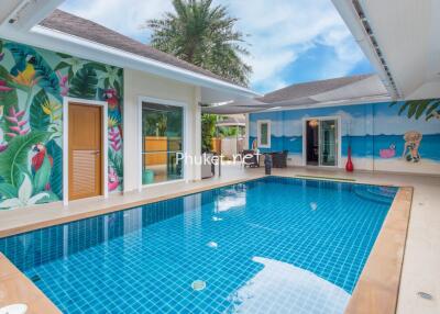 Tropical-themed outdoor pool area with vibrant murals