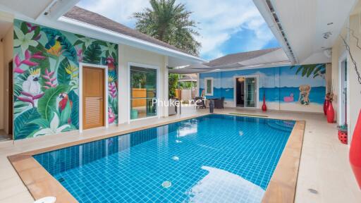 Tropical-themed outdoor pool area with vibrant murals