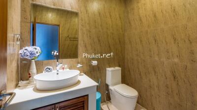 Modern bathroom with sink, toilet, and decorative flowers