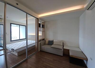 Contemporary living area with a glimpse of the adjoining bedroom