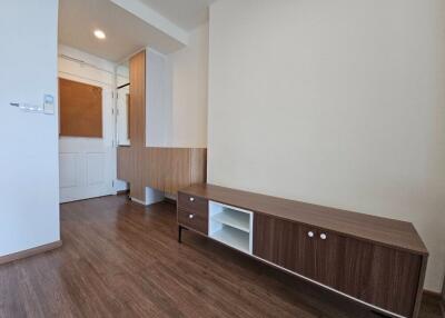 Minimalist bedroom with wooden flooring and a low wooden cabinet