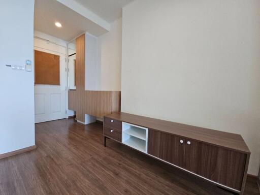 Minimalist bedroom with wooden flooring and a low wooden cabinet