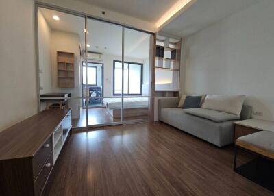 Modern living area with glass partition leading to bedroom