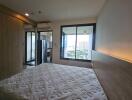 Modern bedroom with white mattress, wooden headboard, balcony view, and large sliding mirror door