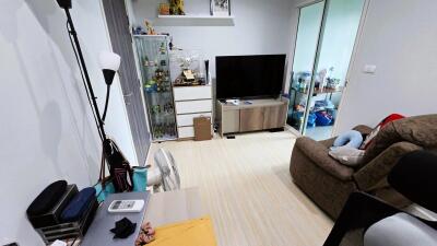 Cozy living room with a TV, shelves, and a comfortable chair.