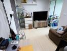 Cozy living room with a TV, shelves, and a comfortable chair.