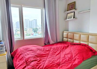 Well-lit bedroom with a large window and city view