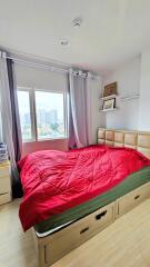 Well-lit bedroom with a large window and city view