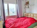 Well-lit bedroom with a large window and city view