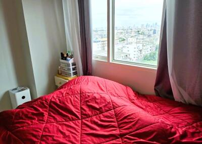 Bedroom with a large window and red quilt