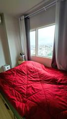 Bedroom with a large window and red quilt