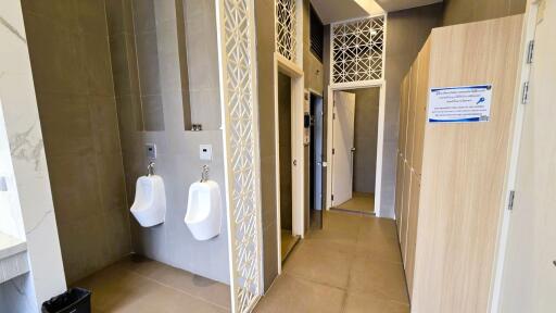 Modern bathroom with urinals and stall doors