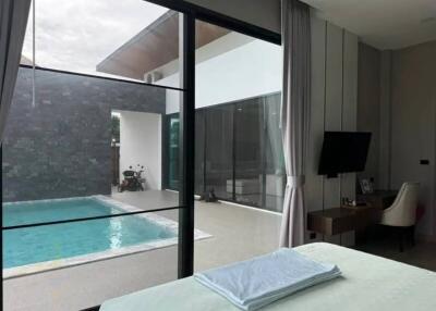 Modern bedroom with view of the pool through large glass doors