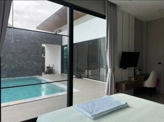 Modern bedroom with view of the pool through large glass doors