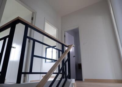 A view of the upstairs hallway with doors leading into different rooms