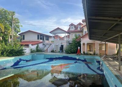 Outdoor view of a house with an empty swimming pool