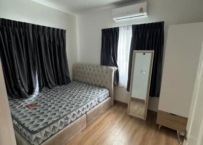 Bedroom with bed, mirror, air conditioning, and wooden floor