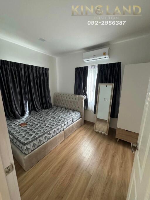 Bedroom with bed, mirror, air conditioning, and wooden floor