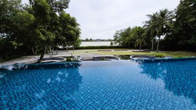 Infinity pool with a scenic view of trees and a lake