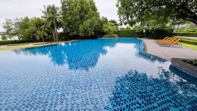 Spacious outdoor swimming pool surrounded by lush greenery