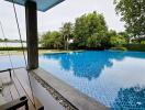 Luxury outdoor swimming pool with surrounding lush greenery