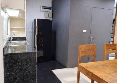 Modern kitchen area with dining table and black granite countertops