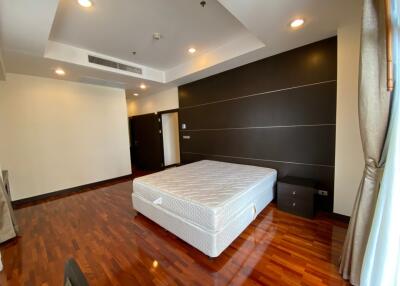 Spacious bedroom with hardwood flooring and large bed