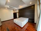 Spacious bedroom with hardwood flooring and large bed