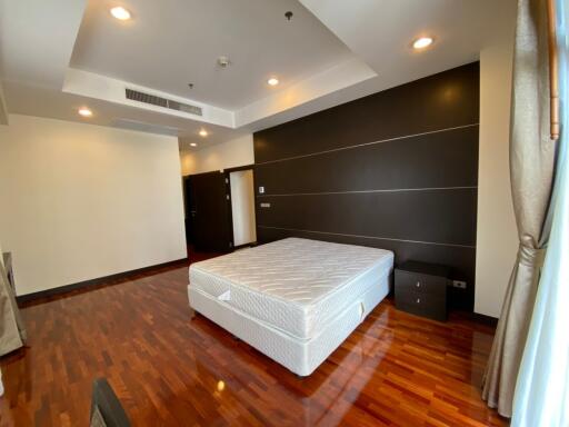 Spacious bedroom with hardwood flooring and large bed