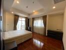 Spacious bedroom with wooden floor and large windows