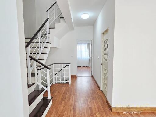 Modern hallway with wooden flooring and staircase