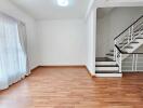 Spacious living room with wooden flooring and staircase