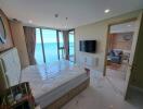 Bedroom with a large window view of the ocean and an adjacent living room