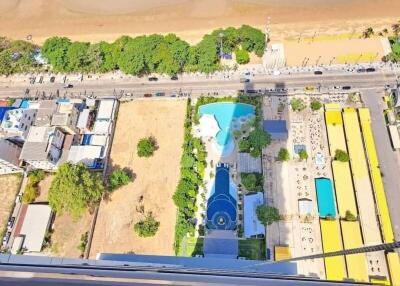 Aerial view of a beachfront property with a pool and surrounding greenery